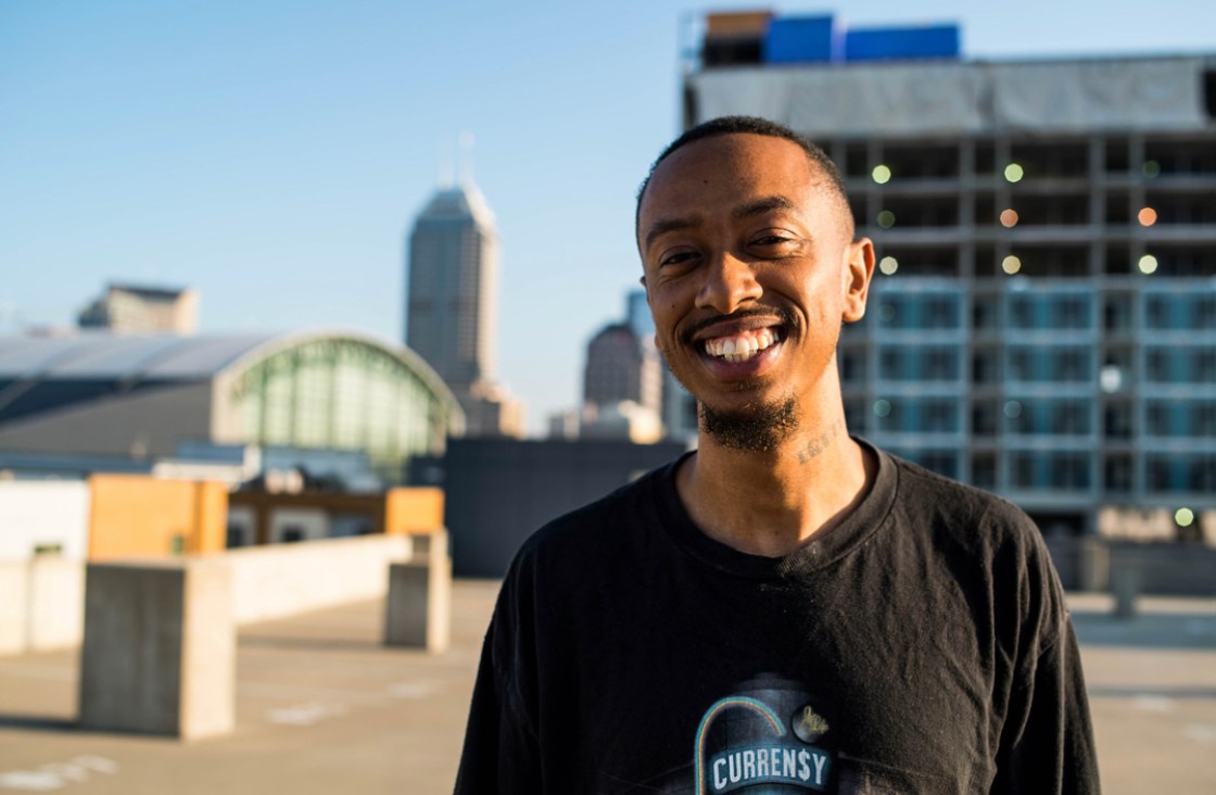 musician diop poses in front of indianapolis skyline