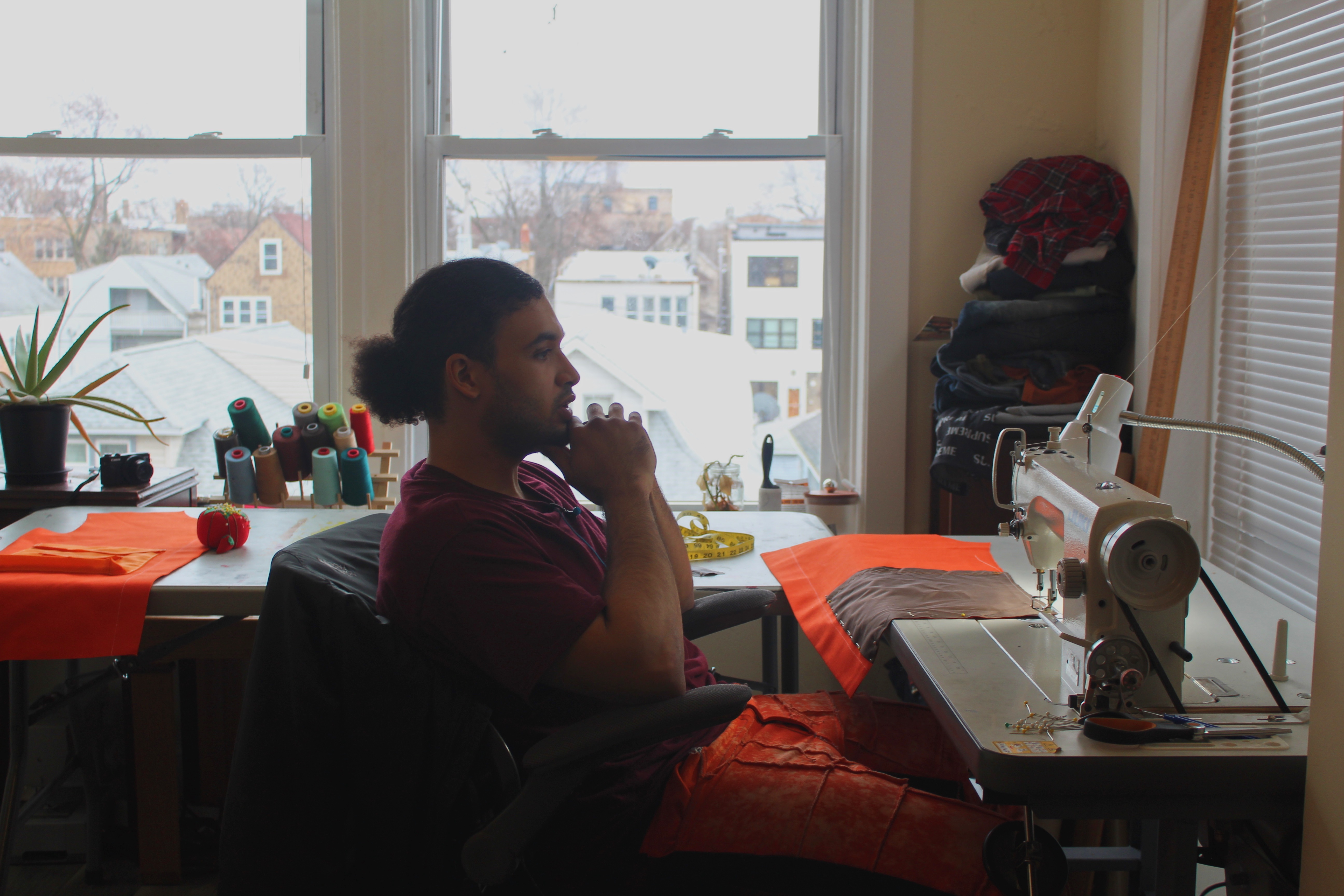 Swaintheory thinks at his sewing table in Chicago